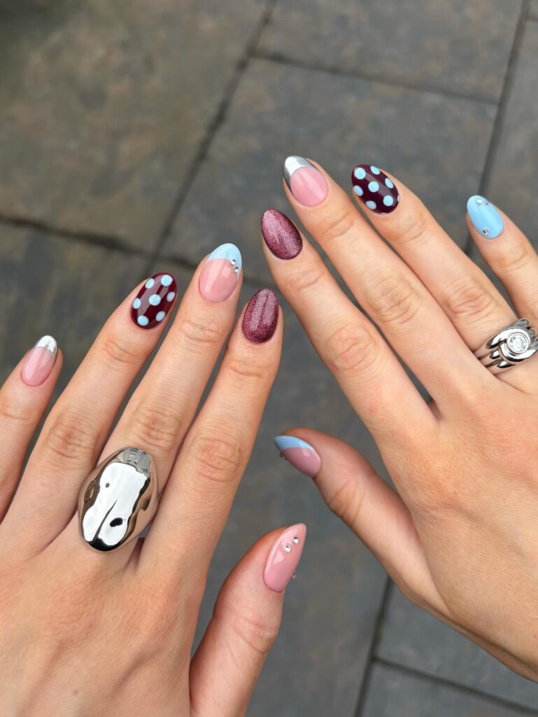 Colorful nails with polka dots, metallic accents, and rings featuring studded designs for spring 2026 trends. Credits: @thenaillologist