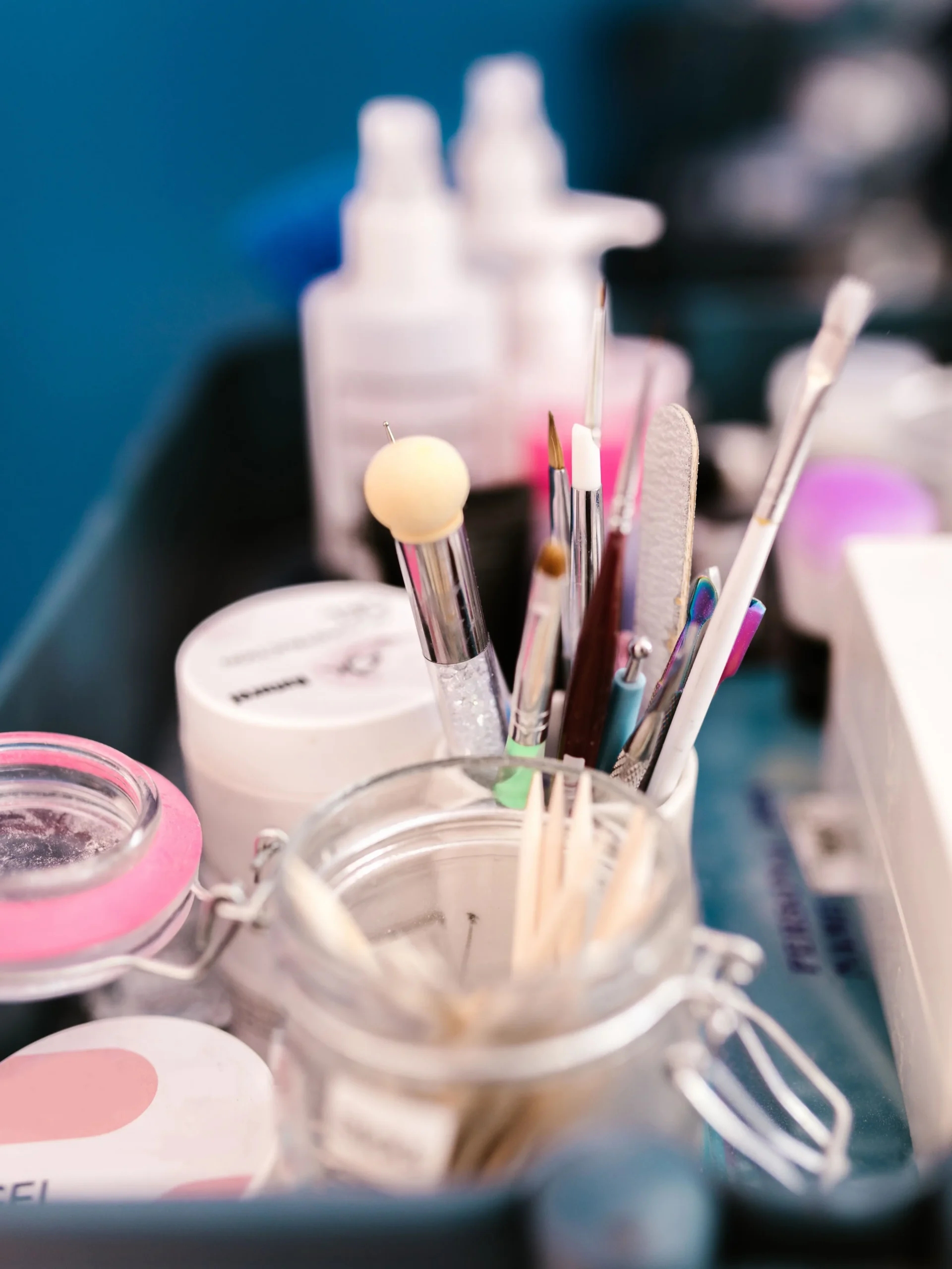 Close-up of a nail tech’s workstation in a salon showing manicure tools, brushes and products