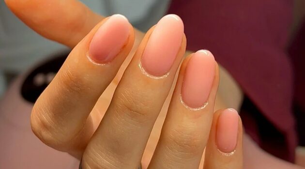 Close-up van een sheer roze BIAB-manicure