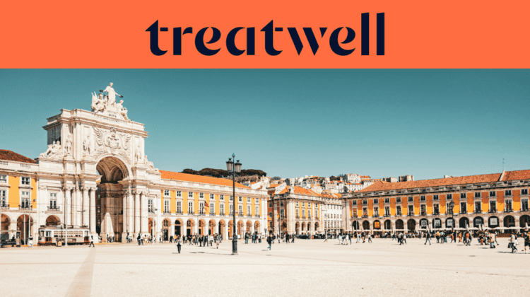 Een brede banner met het Treatwell-logo in donkerblauw op een oranje achtergrond bovenaan. Onder het logo een zonnige foto van het Praça do Comércio in Lissabon, met de witte Arco da Rua Augusta, gele gebouwen met boogvormige galerijen en wandelende mensen op het uitgestrekte voetgangersplein onder een strakblauwe hemel.