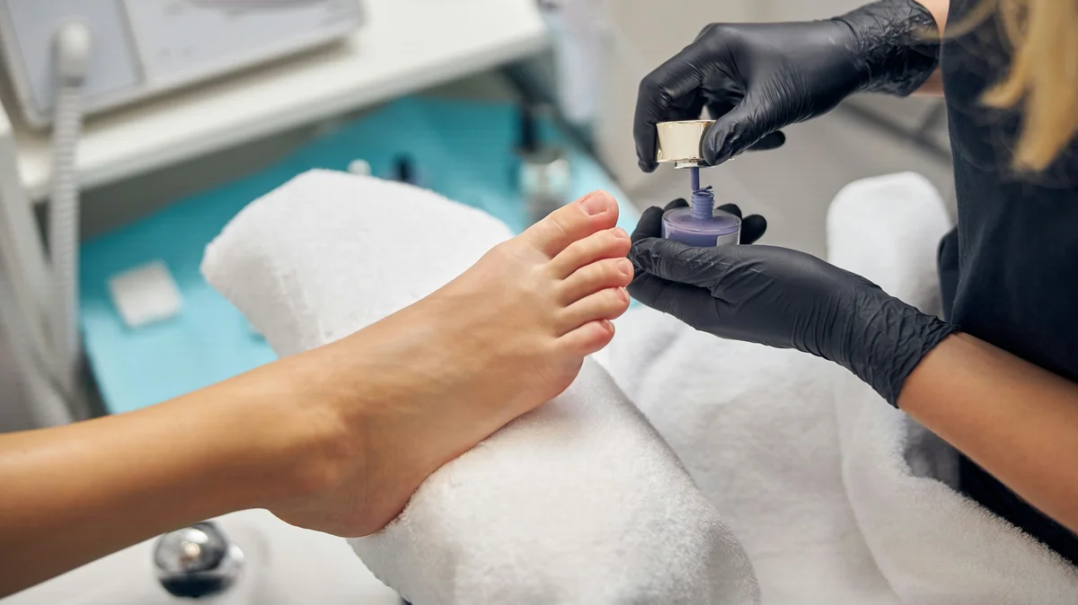 Close-up van een stylist die een klant een pedicure geeft in een salon